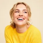 Happy woman wearing yellow sweater after vitamin B12 deficiency symptoms injection relief