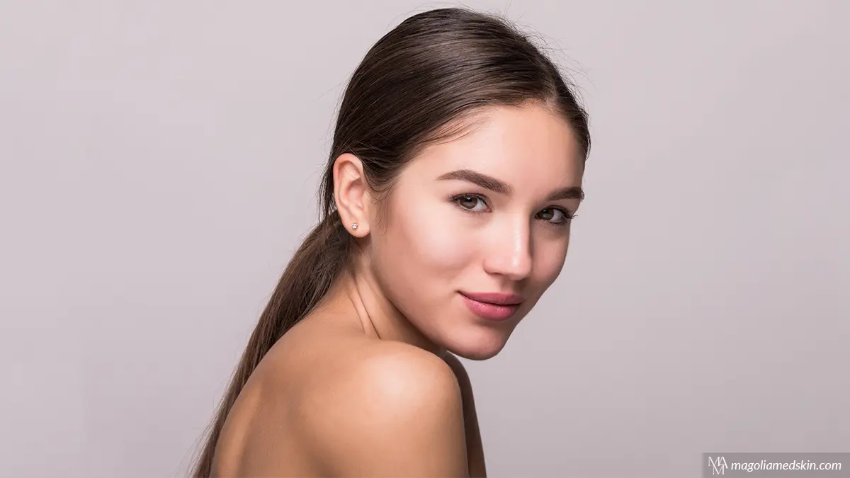Beautiful woman with glowing skin, naturally full lips, and defined facial contours, illustrating how long do dermal fillers last in different treatment areas